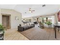 Spacious living room with large windows, tile flooring, and a ceiling fan at 14821 N 42Nd St, Phoenix, AZ 85032