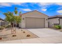 Charming single-story home showcasing a two-car garage and low-maintenance desert landscaping under a bright blue sky at 17431 W Via De Luna Dr, Surprise, AZ 85387