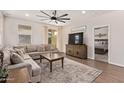 Comfortable living room featuring a large sectional sofa, ceiling fan, and sliding glass doors to the backyard at 17431 W Via De Luna Dr, Surprise, AZ 85387