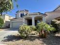 Charming home with manicured landscaping, desert plants, and attached two-car garage at 17477 W Woodrow Ln, Surprise, AZ 85388