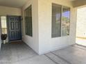 Covered porch with neutral walls, a glass paneled entry door, and dual pane windows at 17477 W Woodrow Ln, Surprise, AZ 85388