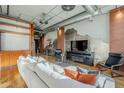 Bright living room featuring hardwood floors, exposed brick walls, ductwork, and an open floor plan at 21 E 6Th St # 311, Tempe, AZ 85281