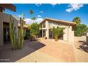 A backyard patio features desert landscaping, high ceilings, and large picture windows at 302 E Acapulco Ln, Phoenix, AZ 85022