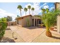 Paver patio with mature landscaping, a desert garden and an outdoor dining set at 302 E Acapulco Ln, Phoenix, AZ 85022