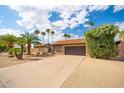 Charming single-story home with a spacious driveway, desert landscaping, and a terracotta-tiled roof at 302 E Acapulco Ln, Phoenix, AZ 85022