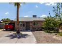 Charming single-story home with a palm tree in the front yard and covered parking at 3311 E Harvard St, Phoenix, AZ 85008