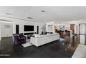 Bright open-concept living room with sleek furniture, modern design, and access to the kitchen at 3710 E Hazelwood St, Phoenix, AZ 85018