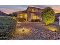 Beautifully illuminated home exterior with a neatly landscaped yard and a welcoming desert garden at sunset at 3900 S Velero St, Chandler, AZ 85249