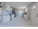 Modern kitchen featuring white cabinets, stainless steel appliances, and tiled flooring at 3946 W Monte Vista Rd, Phoenix, AZ 85009