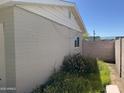 Exterior wall of the home, showcasing brickwork, a small window, and minimal landscaping at 3948 E Monterosa St, Phoenix, AZ 85018