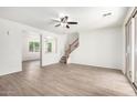 Spacious living room with wood-look floors and staircase access, seamlessly connecting to other areas at 4149 E Devon Dr, Gilbert, AZ 85296