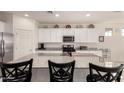 Bright kitchen featuring white cabinets, stainless steel appliances, and a granite island at 5612 N 109Th Ave, Phoenix, AZ 85037