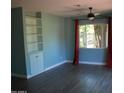 Bright bedroom with built-in shelving, a ceiling fan, hardwood floors, and a sunlit window at 717 E State Ave, Phoenix, AZ 85020