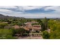 Breathtaking aerial view highlighting the estate's beautiful terracotta roof, lush greenery, and mountain views at 7525 N Shadow Mountain Rd, Paradise Valley, AZ 85253