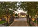 Elegant home with mature landscaping framed by trees and stone walls at 7525 N Shadow Mountain Rd, Paradise Valley, AZ 85253