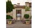 Charming courtyard entrance with a rustic gate and landscaped planters at 7525 N Shadow Mountain Rd, Paradise Valley, AZ 85253