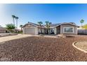 Inviting single-story home with desert landscape, two-car garage, and solar panels at 7966 W Surrey Ave, Peoria, AZ 85381