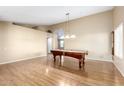 Open living room featuring neutral walls, gleaming hardwood floors and pool table at 7966 W Surrey Ave, Peoria, AZ 85381
