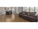 Open-concept living room featuring wood-look floors, a sofa, a dining table, and natural light at 821 E Chicago St, Chandler, AZ 85225