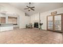 Bright living room featuring a fireplace, ceiling fan, tile flooring, bar access to the kitchen and backyard doors at 930 E Page St, Gilbert, AZ 85234
