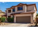 Charming two-story home features a neutral color palette and a well-maintained front yard at 10313 W Windsor Ave, Avondale, AZ 85392