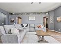 Cozy living area with a comfortable sectional sofa, decorative shelving, and modern decor at 11550 W Mule Deer Ct, Surprise, AZ 85378