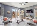 Bright living room featuring sliding glass doors, ceiling fan, and comfortable seating at 11550 W Mule Deer Ct, Surprise, AZ 85378