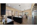 Eat-in kitchen featuring dark cabinets, granite counters, an island, and stainless steel appliances at 13614 N 12Th Way, Phoenix, AZ 85022