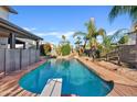 Backyard pool featuring a diving board and lush greenery, creating a private oasis at 1411 W Mendoza Ave, Mesa, AZ 85202