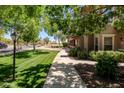 Manicured community with mature shade trees, green grass and sidewalks at 14250 W Wigwam Blvd # 121, Litchfield Park, AZ 85340