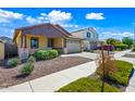 Beautiful home with a well-manicured lawn, attractive landscaping, and a two-car garage with a long driveway at 14413 W Eugene Ter, Surprise, AZ 85379