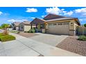 Charming single-story home showcasing a two-car garage, well-maintained landscaping, and a welcoming front porch at 14413 W Eugene Ter, Surprise, AZ 85379