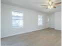 Bright living room with light wood floors, ceiling fan, and two large windows at 1450 E Topeka Dr, Phoenix, AZ 85024