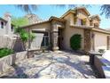 A Southwestern-style home with a desert landscape and a large stone driveway at 14833 S 14Th Pl, Phoenix, AZ 85048