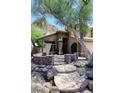 A well-kept home featuring a desert landscape with mature trees and a stone walkway at 14833 S 14Th Pl, Phoenix, AZ 85048