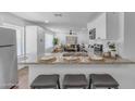 Open-concept kitchen with granite countertops, a breakfast bar, and a view into the living area at 1511 E Harmony Ave, Mesa, AZ 85204