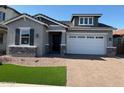 Beautiful single-story home with a manicured lawn, stone accents, and a spacious two-car garage at 15620 W Georgia Dr, Surprise, AZ 85379