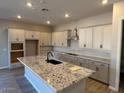 Bright kitchen featuring an island, granite countertops, and stainless steel appliances at 15620 W Georgia Dr, Surprise, AZ 85379