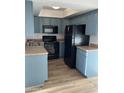 This kitchen features blue cabinets, laminate countertops and black appliances at 2121 W Royal Palm Rd # 2049, Phoenix, AZ 85021