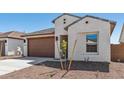 Home featuring a two-car garage, desert landscaping, and light-colored exterior paint at 23419 W Albeniz Pl, Buckeye, AZ 85326