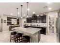 Spacious kitchen with dark cabinets, stainless steel appliances, a granite island, and an open layout at 2440 W Arroyo Way, San Tan Valley, AZ 85144
