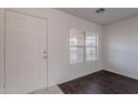 Bright entryway featuring modern wood-look flooring, white walls, and a front door at 30944 N Bramwell Ave, San Tan Valley, AZ 85143