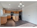 The kitchen features a central island, light wood cabinetry, and modern appliances at 30944 N Bramwell Ave, San Tan Valley, AZ 85143