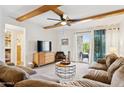 Bright living room features exposed beam ceiling, ceiling fan and sliding glass doors to patio at 3314 N 68Th St # 129, Scottsdale, AZ 85251