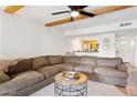 Comfortable living room with exposed beam ceiling, ceiling fan, and view into kitchen at 3314 N 68Th St # 129, Scottsdale, AZ 85251