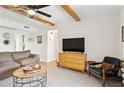 Living room with ceiling fan, exposed beam ceiling, comfortable chair and side table at 3314 N 68Th St # 129, Scottsdale, AZ 85251