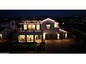 Striking two-story home illuminated at night, featuring a spacious balcony and a two-car garage at 3669 E Boot Track Trl, Gilbert, AZ 85296