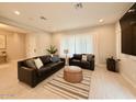 Inviting living room with leather furniture set and light-colored tile flooring at 3669 E Boot Track Trl, Gilbert, AZ 85296