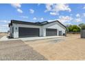 A large three car garage with dark doors offers plenty of parking and storage at 3933 E Freeman Ln, San Tan Valley, AZ 85140