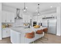 Bright kitchen features stainless appliances, subway tile backsplash, and island with seating at 3933 E Freeman Ln, San Tan Valley, AZ 85140